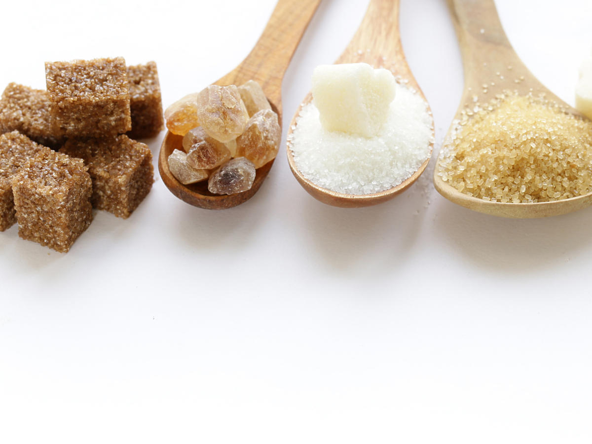 rożne rodzaje cukru na drewnianych łyżkach brązowy i biały cukier w kostkach