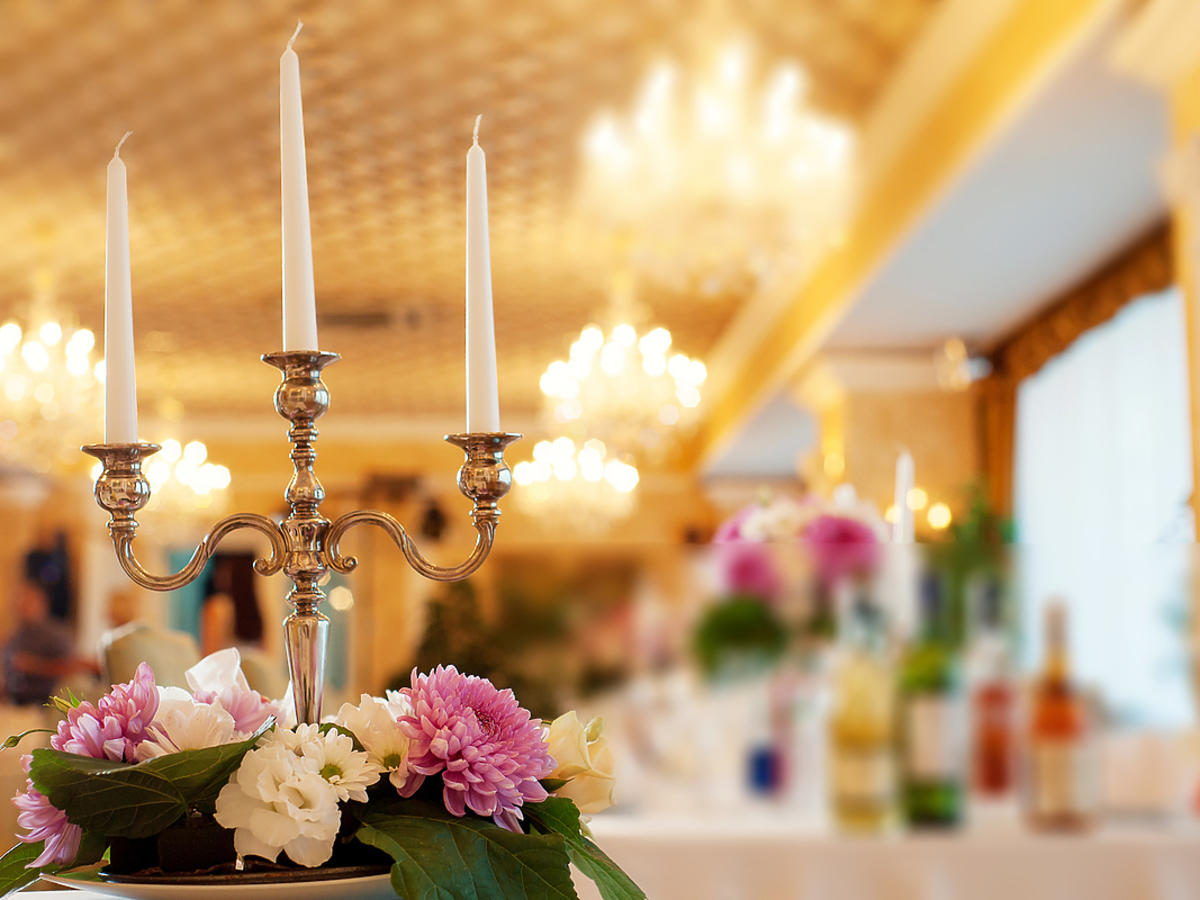 Sala weselna, bez gości, na stole stoi świecznik.