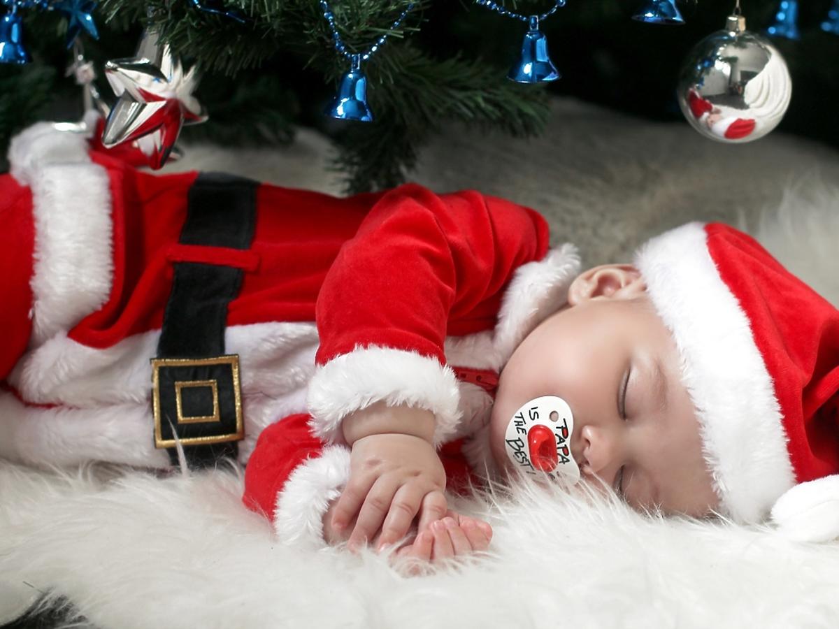 Śpiąceniemowlę w stroju św. Mikołaja.