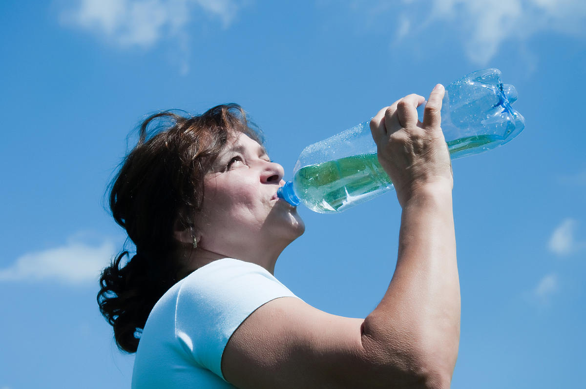 spragniona kobieta pije wodę z butelki