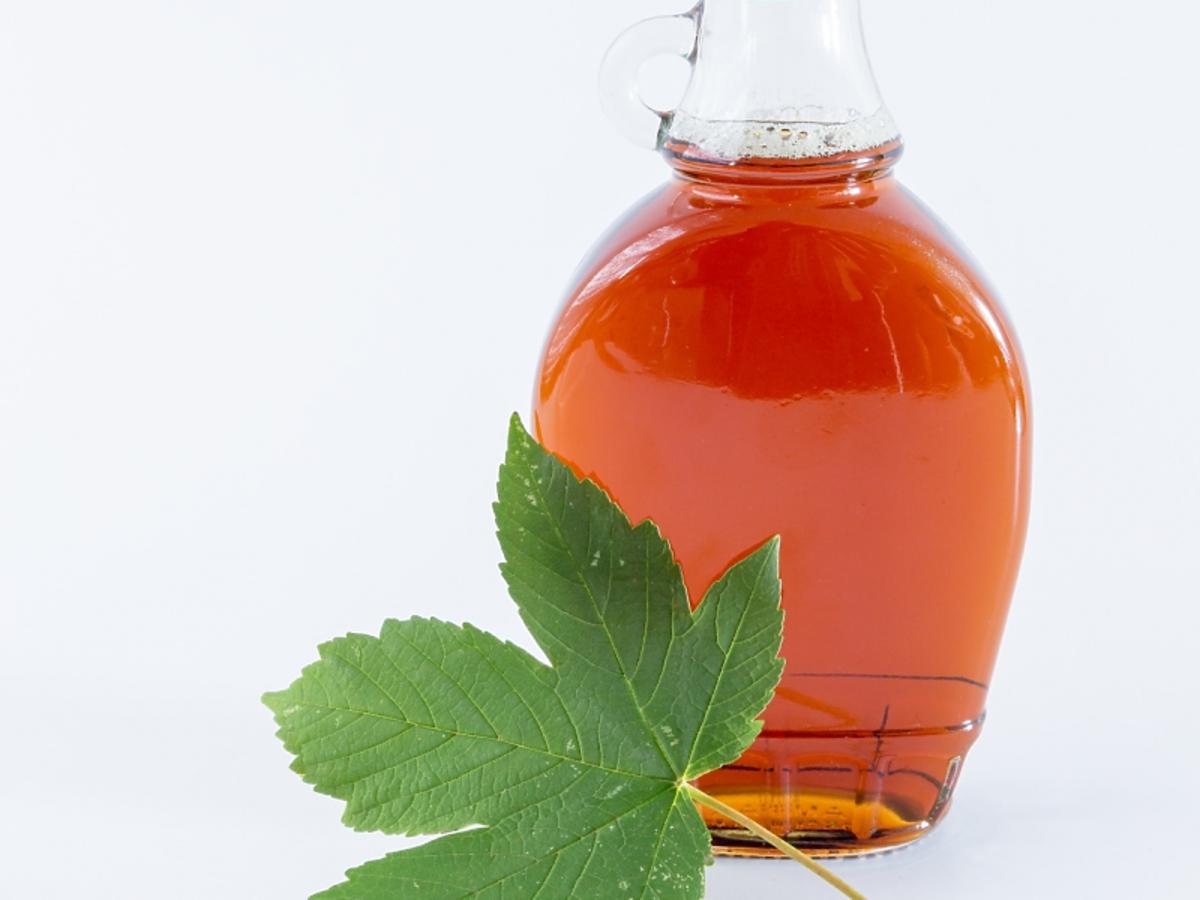 Syrop klonowy w szklanej butelce i liść klonu
