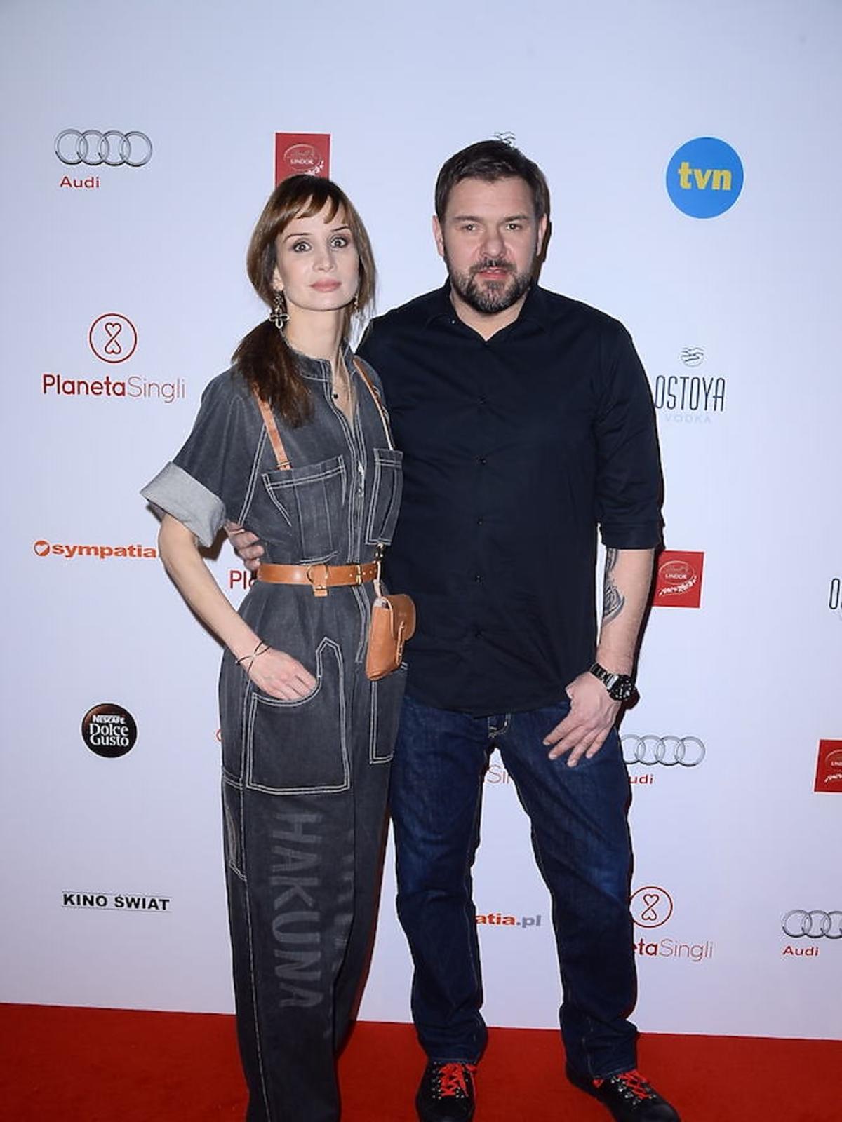 Tomasz Karolak w czarnej koszuli i Viola Kołakowska w czarnym dżinsowym kombinezonie