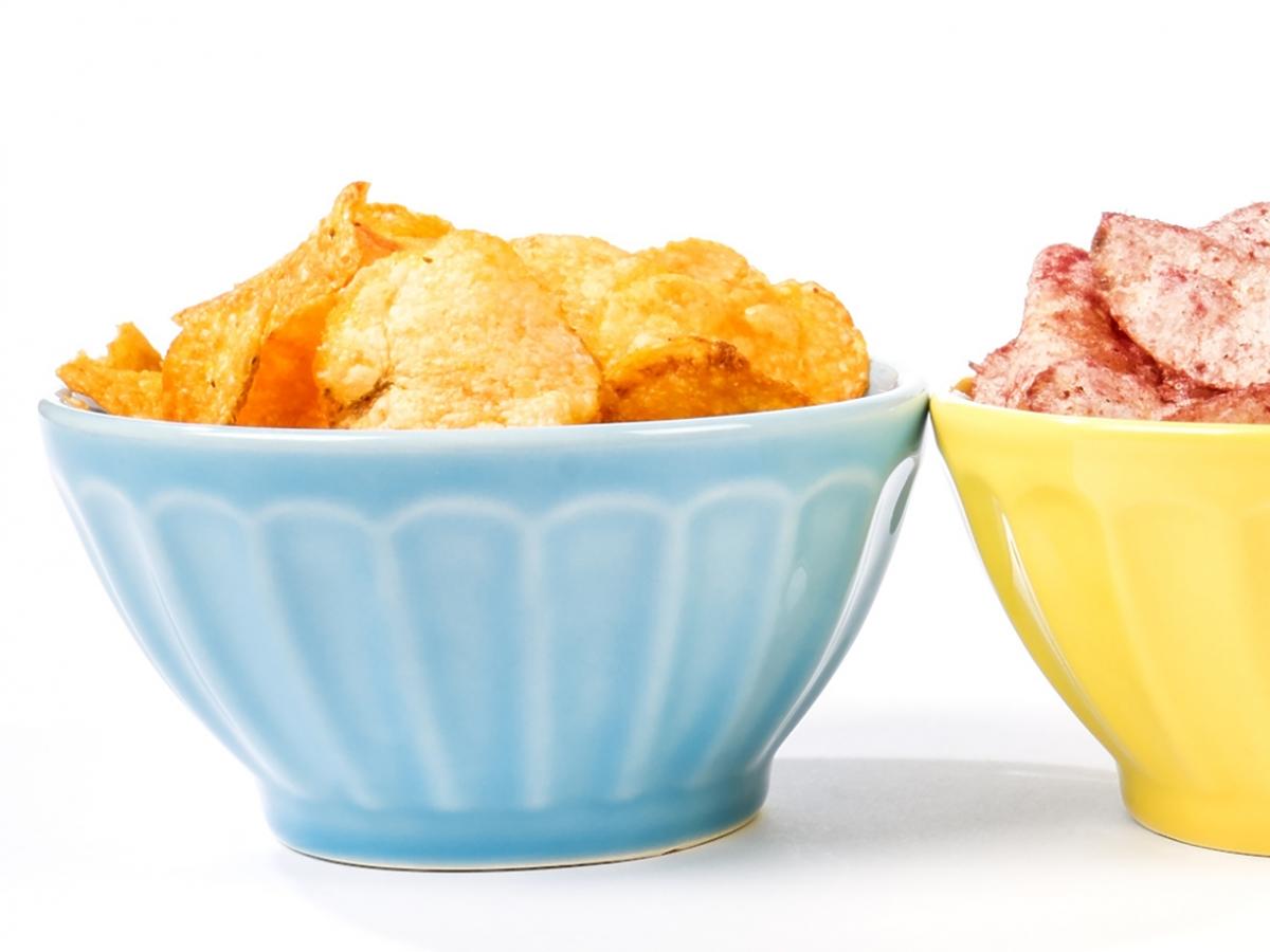 trzy kolorowe miseczki z czipsami w różnych smakach