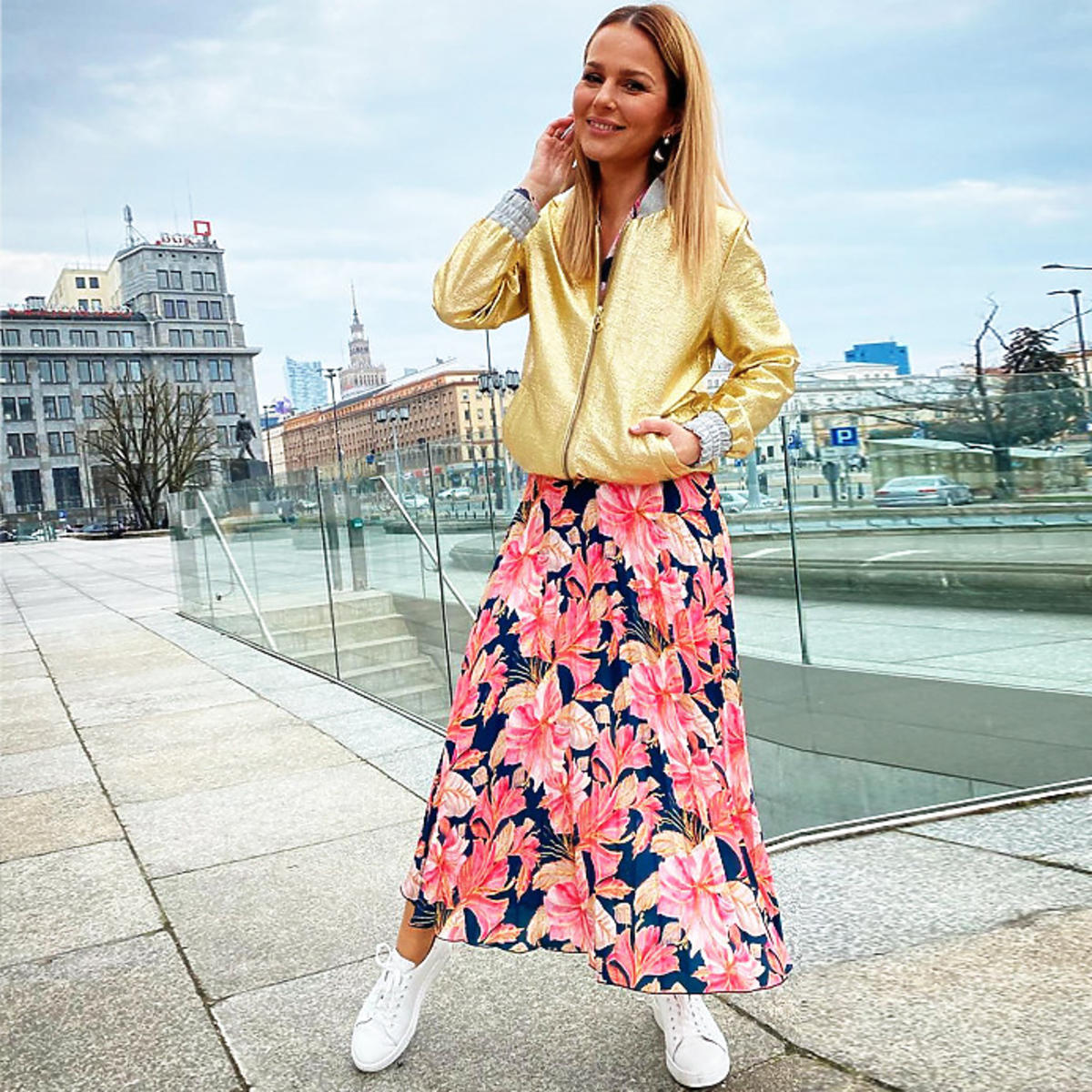 Paulina Sykut w białych adidasach, kwiecistej spódnicy i złotej kurtce