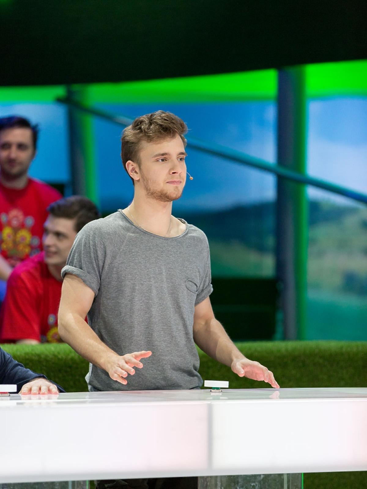 Maciej Musiał w szarym T-shircie w TVP